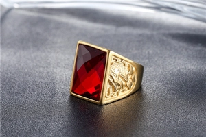 Macro detail of men's gold signet ring featuring red gemstone and side dragon carving