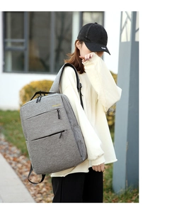 Outdoor model display of gray oxford business backpack with black zipper details
