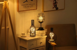 Three creative black iron wire mesh lamps with warm LED fairy lights in a cozy room