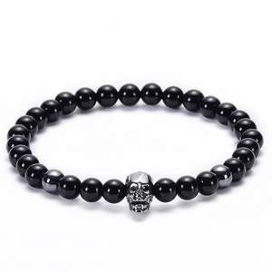 Dettaglio di bracciale gotico con perline di onice nera e ciondolo a forma di teschio