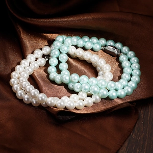Lustrous 8mm white and blue round pearl necklace set on elegant brown silk fabric