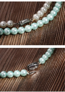 Detail of 8mm round white and blue pearl necklaces with polished metallic clasps