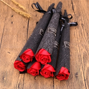 Close-up of 6 red soap roses in black paper cones with Wishes ribbons on wood background