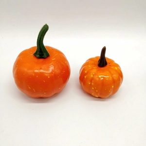 Top view of two lifelike orange foam pumpkins with yellow speckles on white background