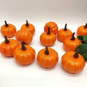 Close-up of twelve bright orange artificial mini pumpkins for festive autumn decoration