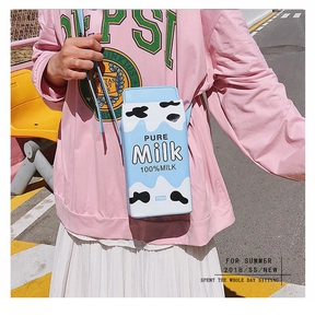 Detail of creative milk carton shoulder bag in blue and white with cow print and strap