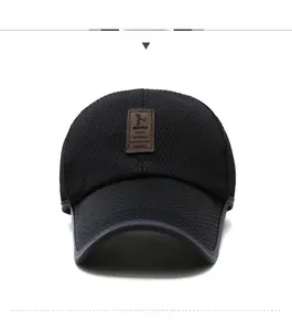 Detail of black mesh baseball cap showing breathable fabric and brown leather brand patch