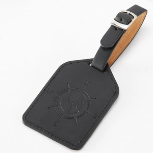 Close-up of black PU leather luggage tag with embossed compass and world map pattern