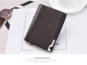 Detail of dark brown leather wallet with litchi texture next to a coffee cup and watch