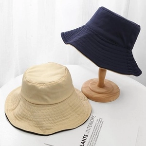 Detailweergave van katoenen vissershoeden in marineblauw en beige voor de zon