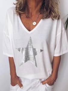 Detail van wit T-shirt met korte mouwen en V-hals met grote zilveren glitterster bedrukking