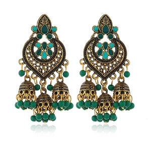Detail of vintage gold Jhumka earrings with green enamel work and beaded tassels