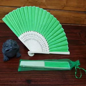 Close-up of emerald green folding fan with matching organza drawstring gift bag set