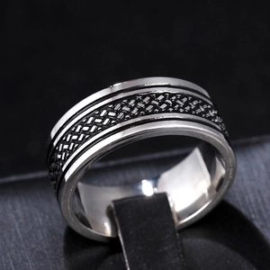 Macro shot of 8mm stainless steel ring with black tire tread and punk texture