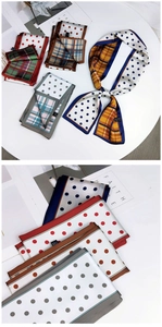 Close-up of double-sided twilly scarves with polka dot and plaid patterns in silk texture