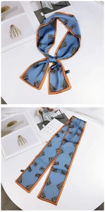 Detail of blue double-sided long skinny scarf with orange edges used as hair ribbon