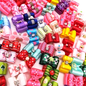 Colorful pet ribbon bows with rhinestones and varied patterns on a clean white background
