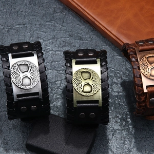 Three punk leather bracelets featuring tree of life metal charms on a dark stone surface