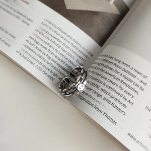 Detail of vintage 925 sterling silver chain ring with smile face charm on magazine