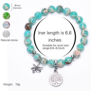 Natural 8mm stone bead bracelet with silver tree of life and flower charms on white background