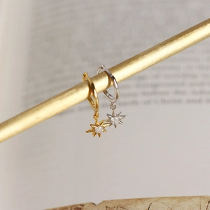 Dettaglio di orecchini a stella ottagonale in argento con zircone in oro e argento