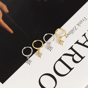 Dettaglio degli orecchini a stella in argento e oro con pietre di zircone scintillanti