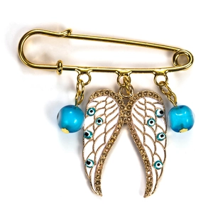 Detailed view of angel wing brooch with blue evil eye beads and golden pin accent