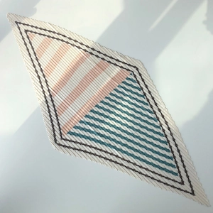Detail of pleated striped scarf featuring beige pink and teal geometric color blocks