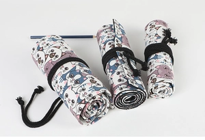 Three rolled canvas pencil wraps with cat prints and black ties shown from above