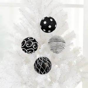 Set of 4 black and silver Christmas ornaments with floral and spiral patterns on a white tree