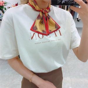Fashionable yellow and red contrast silk scarf tied on a white graphic t-shirt