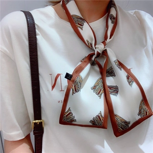 Detail of silk-like neckerchief with geometric patterns tied on neck for styling