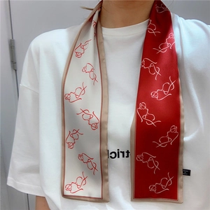 Detail of red and beige silk scarf with minimalist line art on high-quality fabric