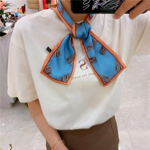 Blue silk scarf with abstract lines and pink edges styled on a white T-shirt
