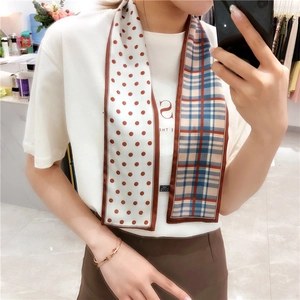 Detail of double-sided twilly scarf featuring red polka dots and classic blue plaid pattern
