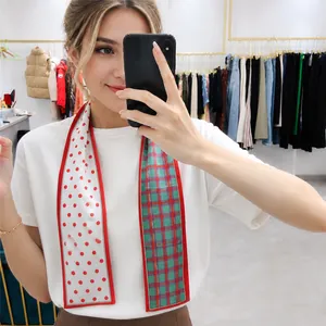 Detail of double-sided twilly scarf featuring red polka dots and green plaid patterns