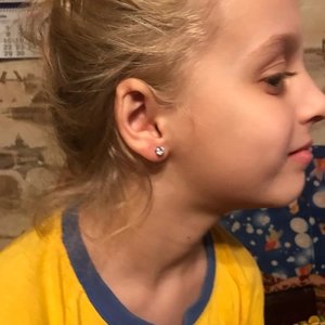 Detail showing a 316 surgical steel crown stud earring worn on a child ear lobe