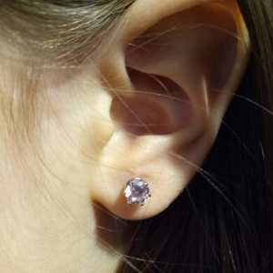 Close-up of purple gemstone ear stud featuring a six-prong crown setting on ear