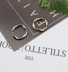 Detailed view of gold and silver irregular wavy twist rings on a stylish minimalist background
