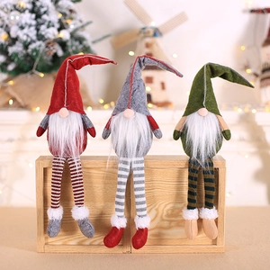 Three Christmas gnomes with striped legs sitting on a wooden box with warm festive lights