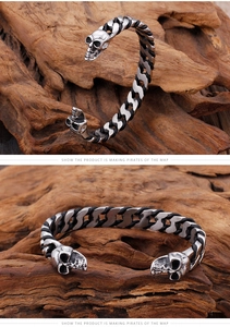 Detail view of woven leather bracelet with antique silver skull heads on wood background