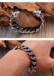 Close-up of wolf head carvings on a braided stainless steel Viking bracelet for men