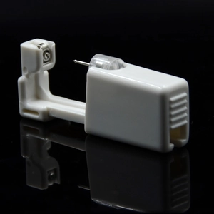Close-up of a white disposable ear piercing gun with a 316L stainless steel needle