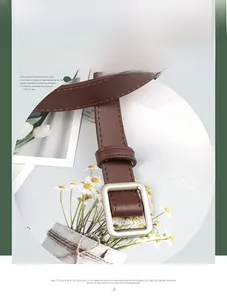 Detail of slim dark brown leather belt with square matte silver buckle and fine texture