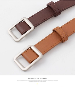 Detail of slim leather belts with matte silver square buckles in brown and caramel