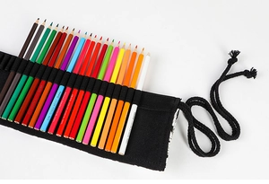 Detail view of black canvas roll-up pencil case with various colored pencils organized