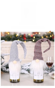 Close-up of knitted Christmas gnome wine bottle covers with grey and polka dot patterns