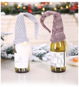 Close-up of Nordic gnome wine bottle covers with knitted hats and white faux fur beards