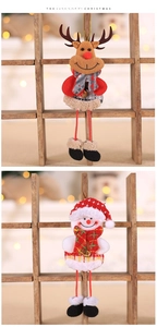Detail view of plush Christmas reindeer and snowman hanging ornaments on wooden rack