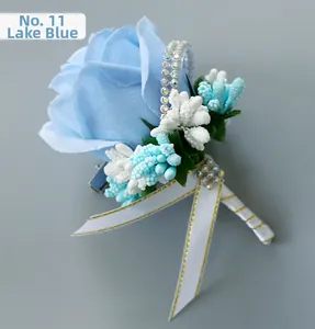 Detail of light blue artificial rose boutonniere with berries, rhinestones, and ribbon